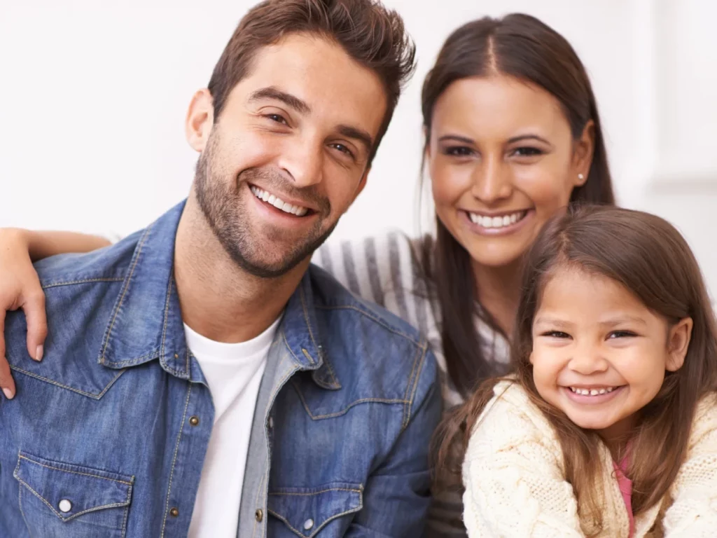 younger couple smiling with child | comprehensive dental care Dentist in Cordova, TN